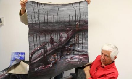Gordon Syron showing one of his paintings of war (C) Syron